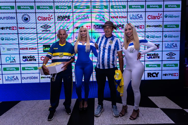 Participantes posam diante do painel de patrocinadores do Congresso Técnico, com o duplo diamante e a assinatura Umbro visíveis ao fundo.