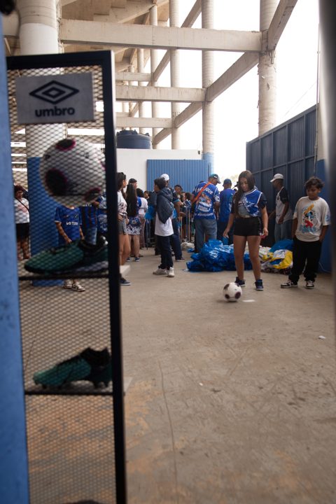 Expositor com a marca Umbro, bola e chuteiras em primeiro plano, enquanto o público participa de uma atividade com bola no espaço da Grande Final da SCP 2026.