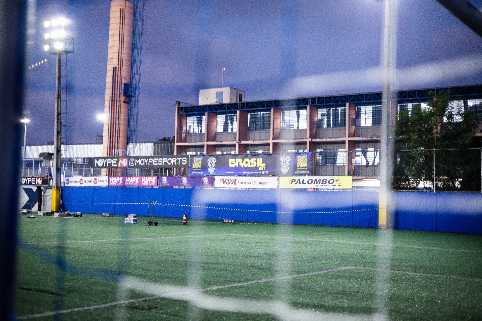 Vista do campo e dos painéis de patrocinadores. A resolução deste enquadramento não permite confirmar a aplicação da Umbro com segurança. Sede, fase e vínculo contratual a validar.