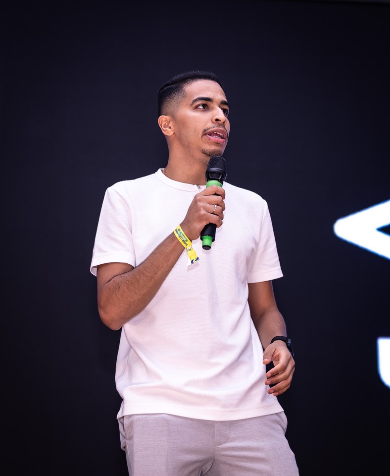 Participante ao microfone no palco do Congresso Técnico, com parte do duplo diamante Umbro visível à direita. Registro complementar do momento; a fotografia não comprova menção verbal à marca.