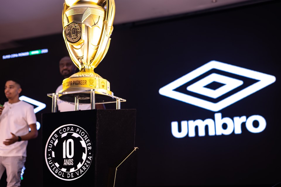 Troféu da SCP em primeiro plano e marca Umbro no painel do palco ao fundo, durante o Congresso Técnico de 2026. A imagem conecta visualmente a identidade da competição à presença da marca.