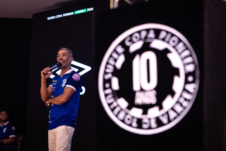 Vista do palco com participante usando camisa institucional da SCP, com aplicação Umbro, e a marca também presente no painel ao fundo. Registro complementar da exposição no Congresso Técnico.