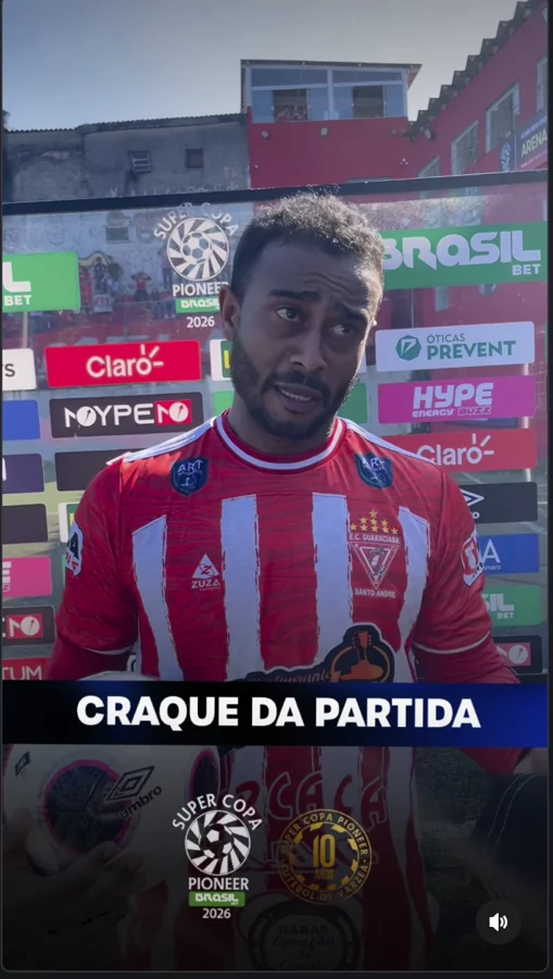 Participante de uniforme listrado em vermelho e branco aparece segurando uma bola com a marca Umbro visível. A captura traz o título “Craque da partida” e o painel de patrocinadores ao fundo. Registro enviado pela Scout Sports para o acervo do Hat-trick Umbro.